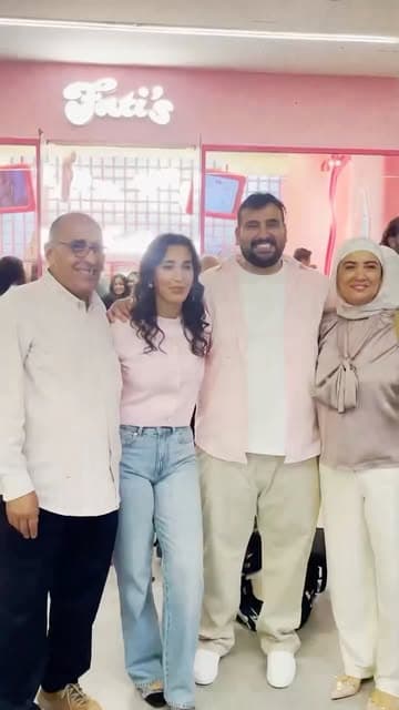 A group outside a pink Fati’s storefront